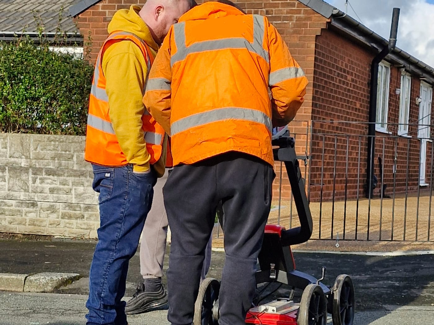 Delegates in hi-vis operating a utility GPR cart on a Sygma training course
