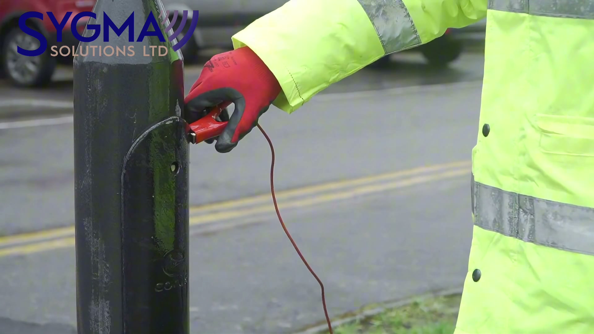 A connection lead clipped onto the door tab of a street lighting column