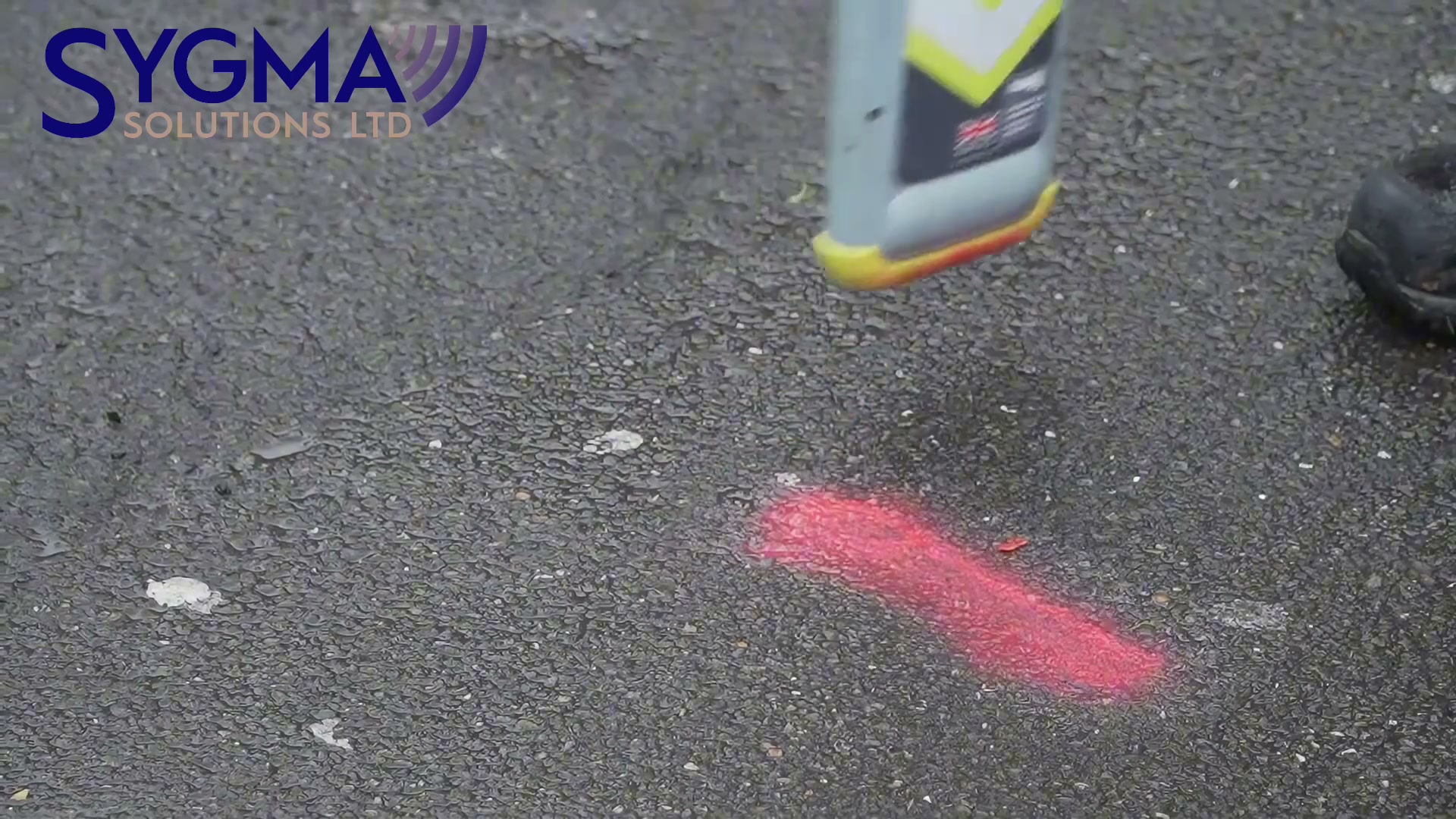 A CAT pinpointing over a fresh red mark on wet tarmac